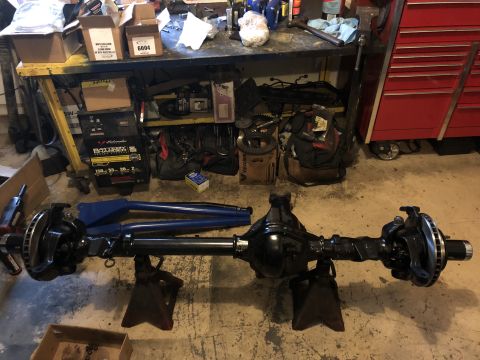 1995 Ford F-150 - A black Ford F-150 rear axle assembly is mounted on jack stands in a garage setting. The axle features disc brakes and is positioned horizo…