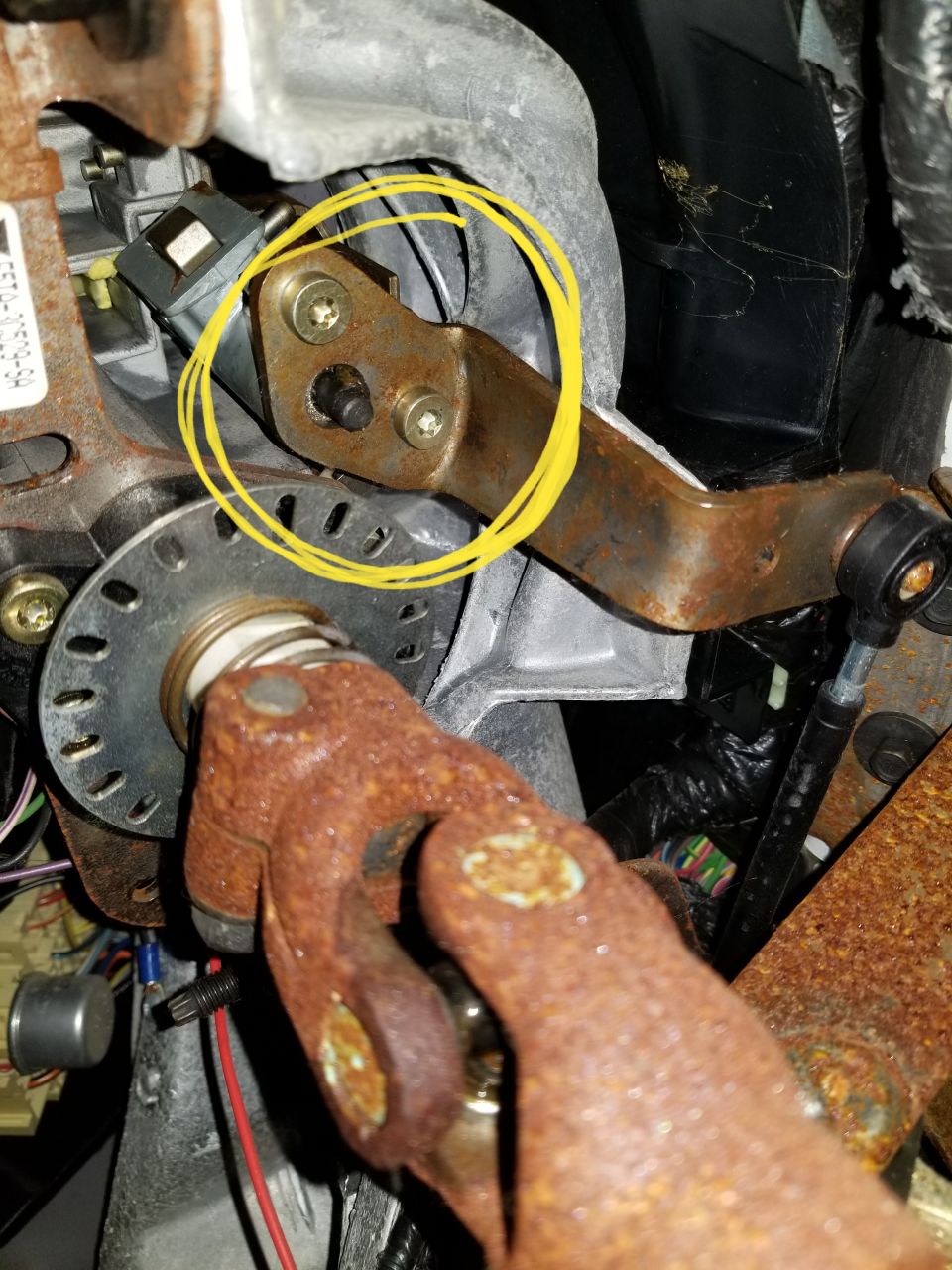 Rusty steering column bracket and universal joint in a vehicle.