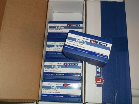 1995 Mercury Grand Marquis - Several boxes of Lapua brand bullets are stacked inside a cardboard box. One box of bullets is open and resting on top of the stack.