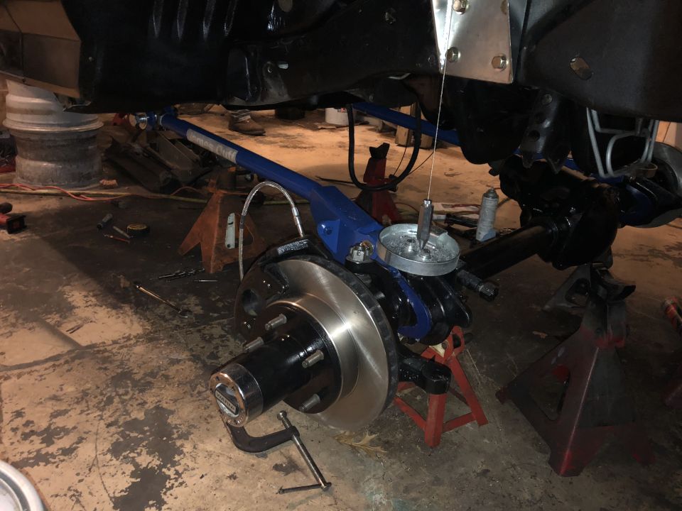 Vehicle front suspension and brake assembly with blue component, rotor, and hub.