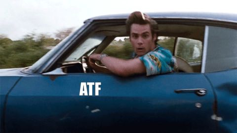 1995 Mercury Grand Marquis - A movie reaction-GIF frame showing a wide-eyed man in a patterned shirt driving a battered blue two-door car with the window down, the text…