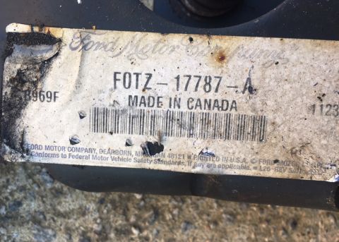 1994 Ford Bronco - A close-up view of a white label with black text, attached to a dark-colored vehicle part. The label shows a part number FOTZ-17787-A, "MAD…