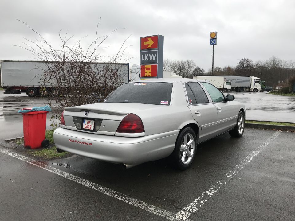 Silver 2003 Mercury Marauder parked in a wet lot, rear driver's side quarter view.