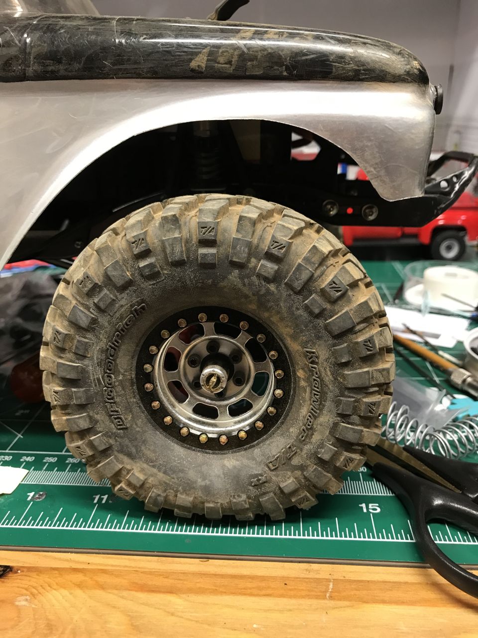 Close-up of a BFGoodrich Krawler T/A off-road tire on a silver and black vehicle.