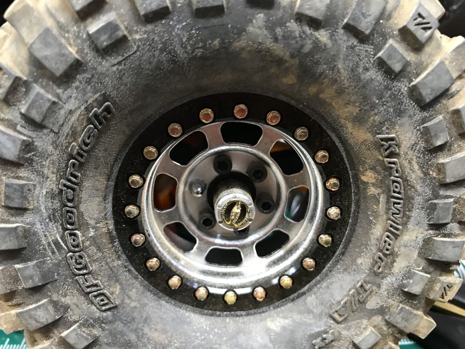 Close-up of a dirty BFGoodrich Krawler T/A tire on a silver beadlock wheel.