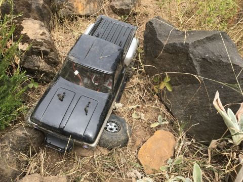 1989 Ford Bronco - This remote-controlled truck appears to be navigating a challenging, rocky outdoor course.