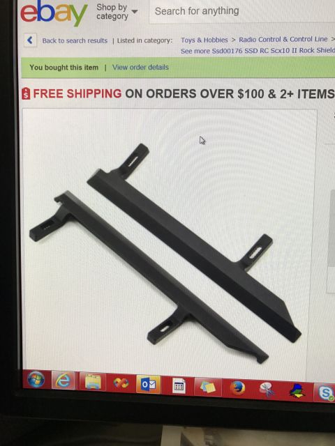 1989 Ford Bronco - Two black plastic parts for a radio control car are shown in this image.