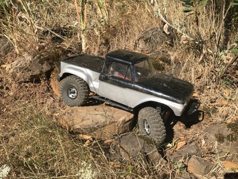 1989 Ford Bronco - This remote-controlled truck is navigating a rocky, outdoor terrain.