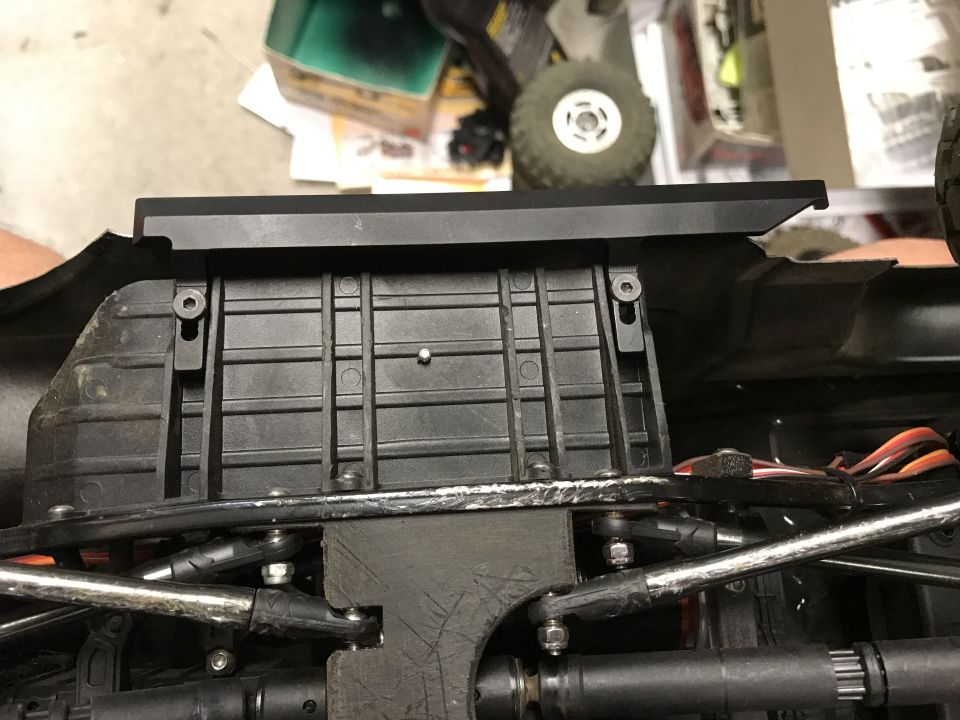 RC car chassis underside with black plastic and metal suspension components