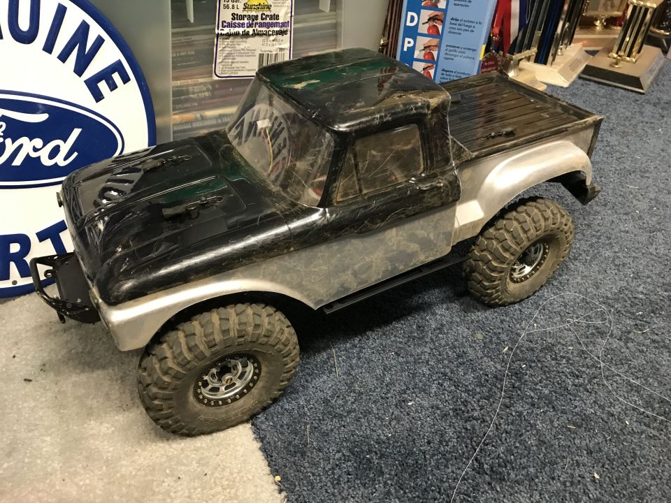 RC truck with black hood and silver body, large off-road tires