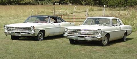1967 Ford Custom Wagon - Two white Ford sedans are parked in a grassy field with a fence in the background.