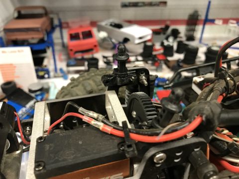 1989 Ford Bronco - Close-up of an RC car's internal mechanics, with multiple model car bodies in the background.