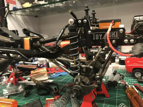 1989 Ford Bronco - A detailed view of an RC car chassis assembly, showing suspension components and electronics.