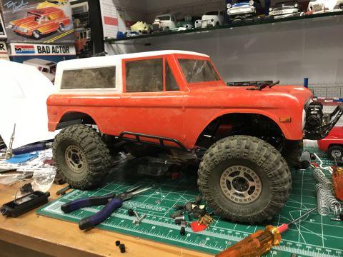 1989 Ford Bronco - RC model SUV body on a workbench with various tools and parts scattered around.