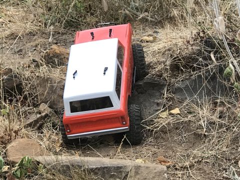 1989 Ford Bronco - A remote-controlled truck navigates a rough, outdoor course.