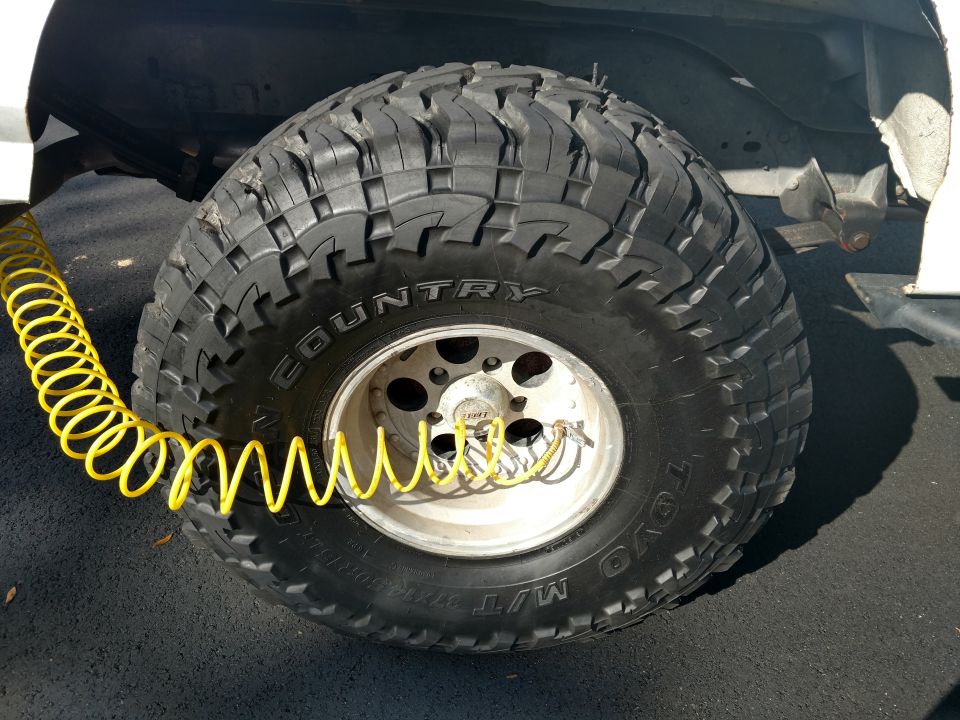 Tire with a yellow air hose attached to the valve stem