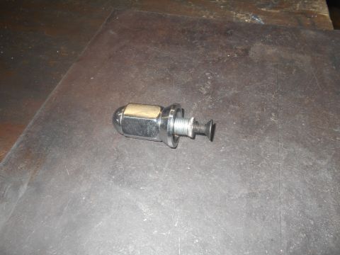 1992 Ford Bronco - A single chrome lug nut and bolt assembly is shown on a dark, textured surface.