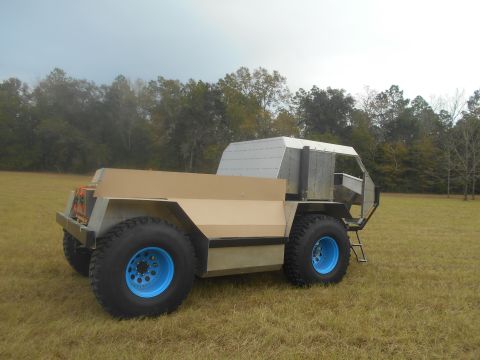 1992 Ford Bronco - This custom-built vehicle features large, bright blue wheels and a unique, angular body design.
