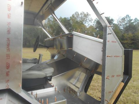 1992 Ford Bronco - The interior of a vehicle is shown under construction with bare metal panels and visible rivets.