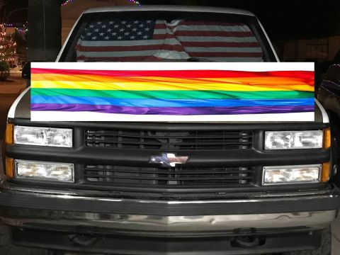1995 Mercury Grand Marquis - This truck displays a rainbow flag sticker across its hood and an American flag sunshade in the windshield.