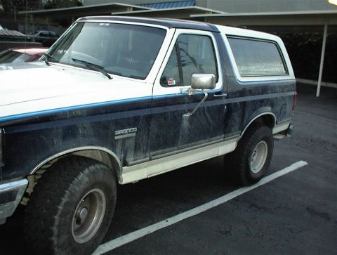 1990 Ford Bronco - This Ford Bronco is parked in a lot, showing its side profile and front quarter.