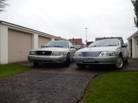 1999 Ford Fairlane - Two sedans, a Mercury Grand Marquis and a Ford, parked in a driveway on an overcast day.