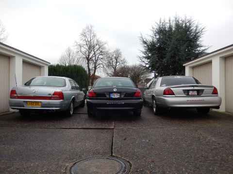 1999 Ford Fairlane - Three sedans are parked in a driveway, with the middle car clearly labeled as a Marauder.
