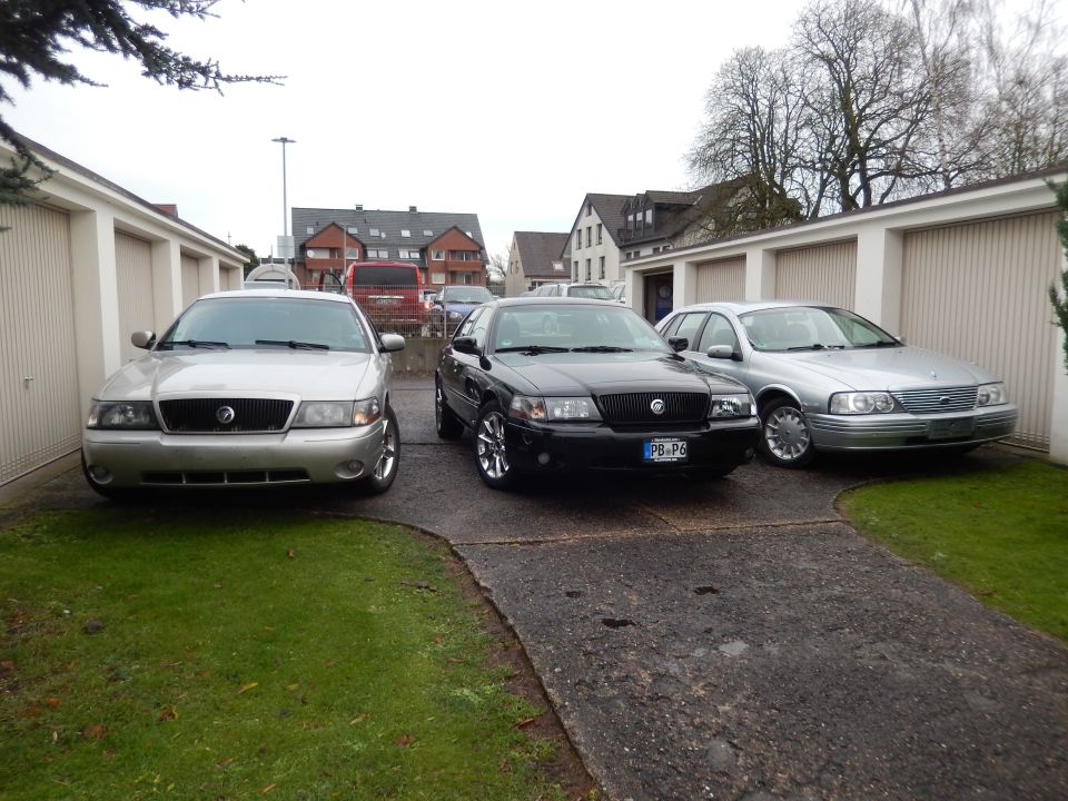 Silver Mercury Grand Marquis, black Mercury Marauder, and silver Ford sedan parked in driveway