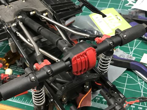 1989 Ford Bronco - Close-up view of an RC car's chassis, highlighting the red-painted differential and suspension system.