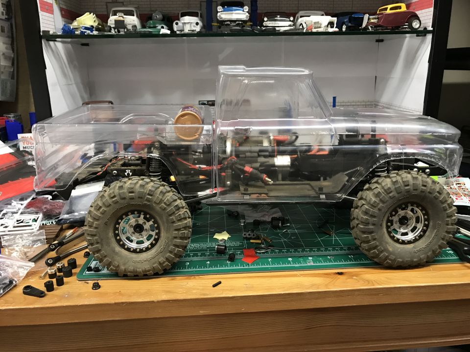 RC truck model with clear body showing internal components and large tires