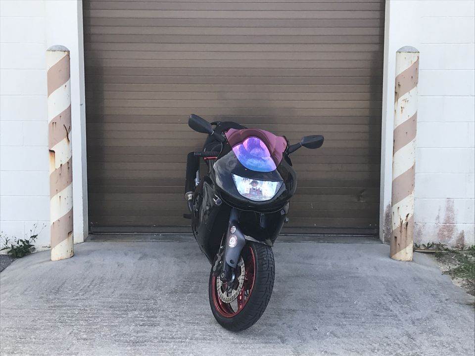 Black sportbike motorcycle parked in front of a garage door