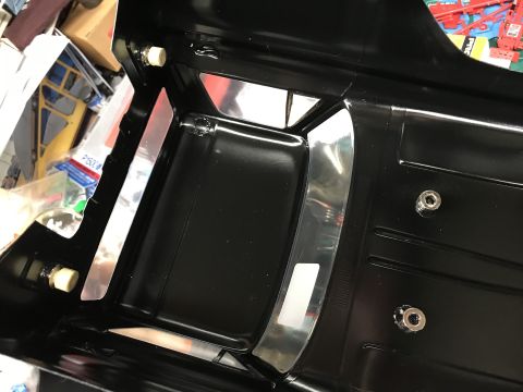 1989 Ford Bronco - Close-up of a black plastic part with silver accents, likely for a model car interior.