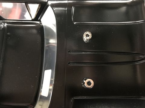 1989 Ford Bronco - Detail shot of a vehicle's interior door panel, showing textured plastic and metallic accents.