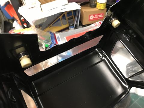 1989 Ford Bronco - Close-up view of a black vehicle's interior panel with metallic accents and visible mounting points.