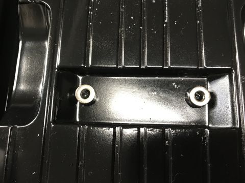 1989 Ford Bronco - Close-up view of a black textured part two visible bolts.