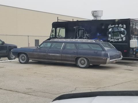 1995 Ford Bronco - A long-wheelbase station wagon is parked beside a food truck with "Born in the D" text.