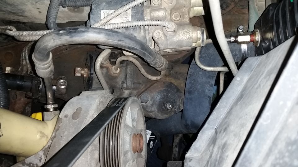 Engine bay close-up with serpentine belt, pulley, and hoses