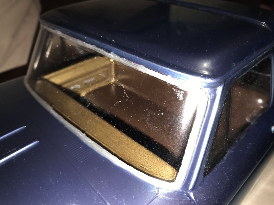 Close-up of dark blue model truck's windshield frame and interior