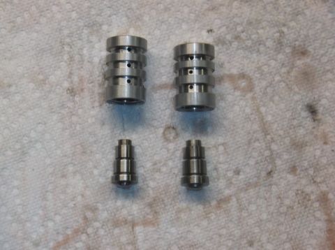 1979 Ford Ranchero - Engine parts: two rocker arms and two valve lifters on a cloth surface.