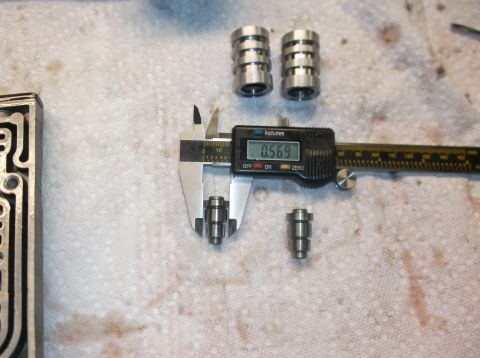 1979 Ford Ranchero - A transmission valve body and several small metal parts are measured with a digital caliper.