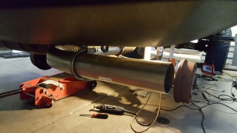 1996 Ford Bronco - Vehicle exhaust system repair in progress with a floor jack and tools.