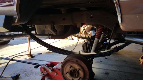 1996 Ford Bronco - Underneath view of a 1996 Ford Bronco's rear suspension system being worked on.
