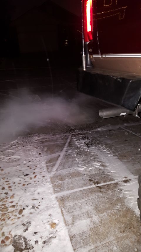 1996 Ford Bronco - Exhaust billows from the tailpipe of a vehicle on a cold, snowy evening.