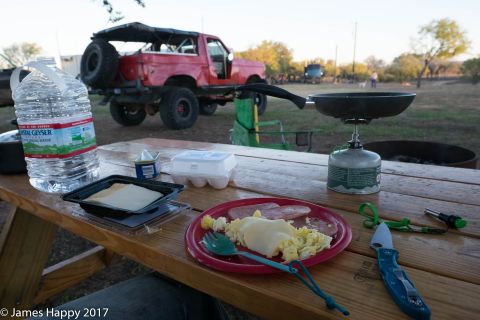 1989 Ford Bronco - 1989 Ford Bronco seen from the rear at a campsite, with a picnic table set up in the foreground.
