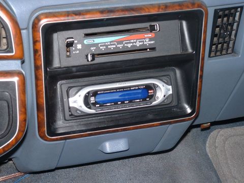 1990 Ford Bronco - Close-up of a car's interior dashboard, showing the climate control panel and an aftermarket stereo system.