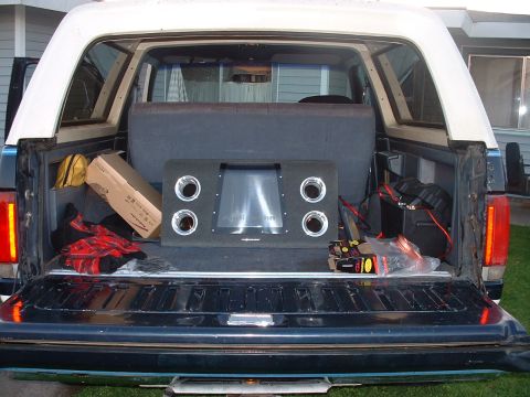 1990 Ford Bronco - Rear view of a 1990 Ford Bronco's cargo area, showing a subwoofer and other items.