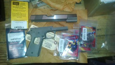 1996 Ford Bronco - Various gun parts, including a frame and slide, are laid out with packaging and labels.