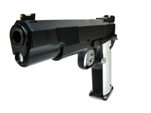 1996 Ford Bronco - A black semi-automatic pistol with silver checkered grips and adjustable sights is shown against a white background.