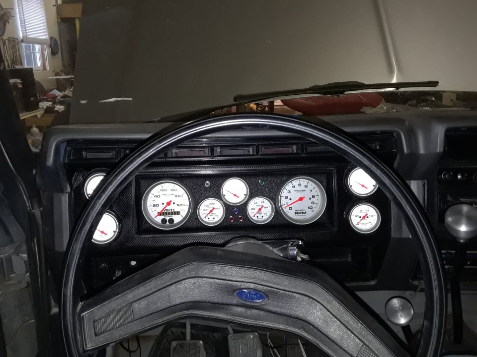 1985 Ford Bronco interior with aftermarket gauges including tachometer and speedometer