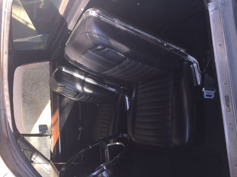 Black vinyl bucket seats and dashboard interior of a classic car
